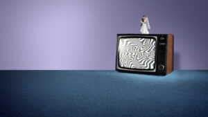 A vintage TV with static, wavy black-and-white lines on the screen sits on blue carpet. On top of the TV is a bride and groom wedding cake topper, set against a purple background.